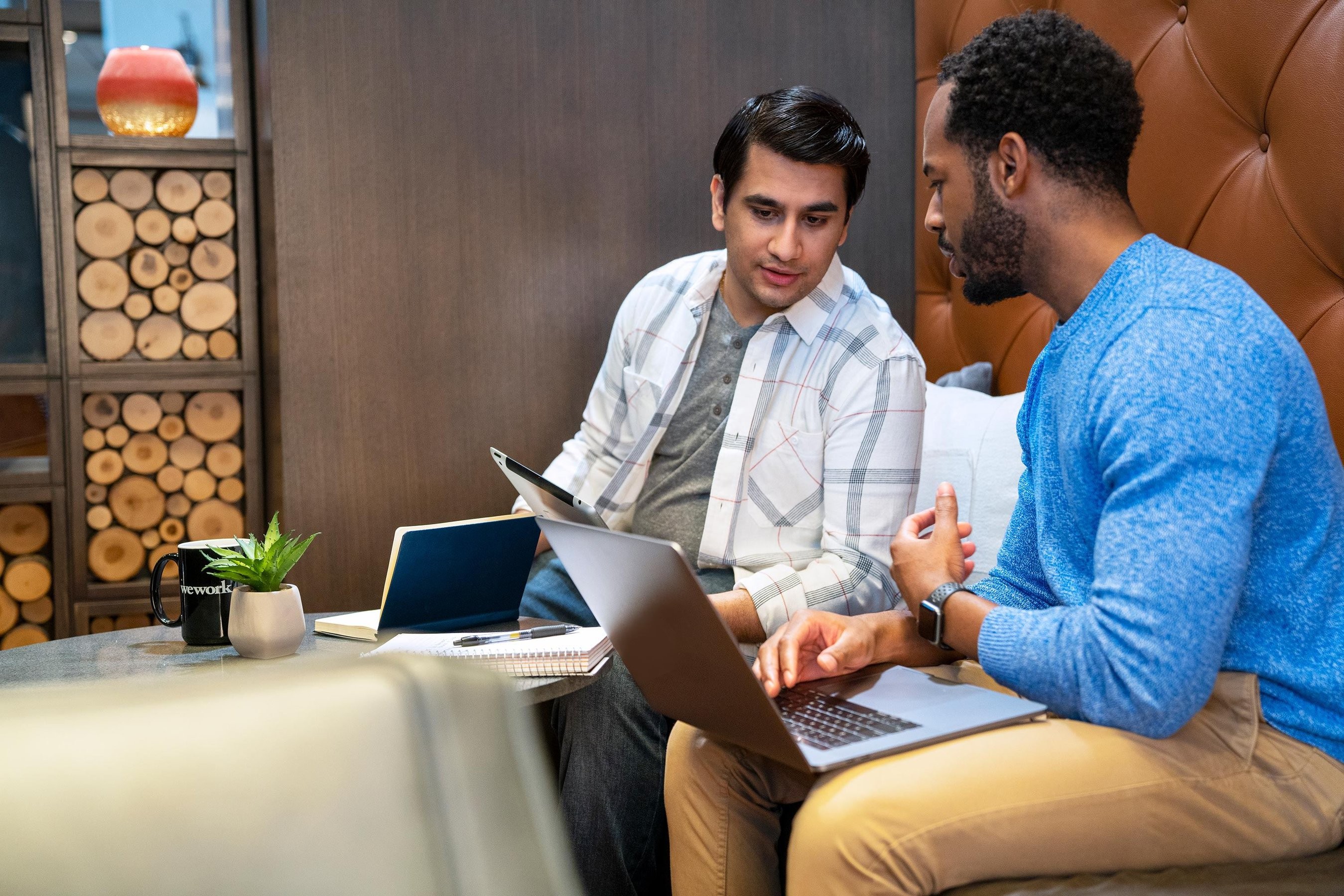 Two students looking at a laptop discussing a project