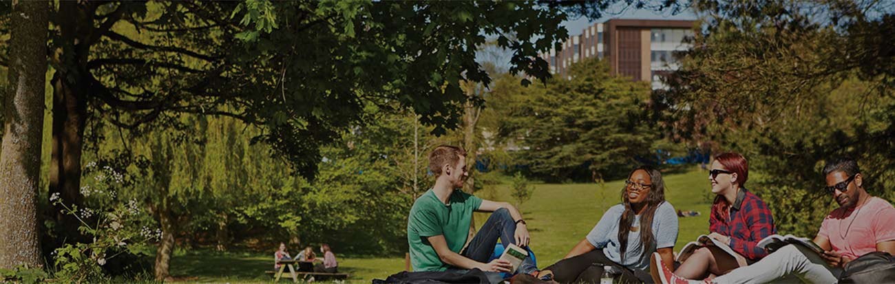 Students sitting outside laughing on the University of Birmingham campus