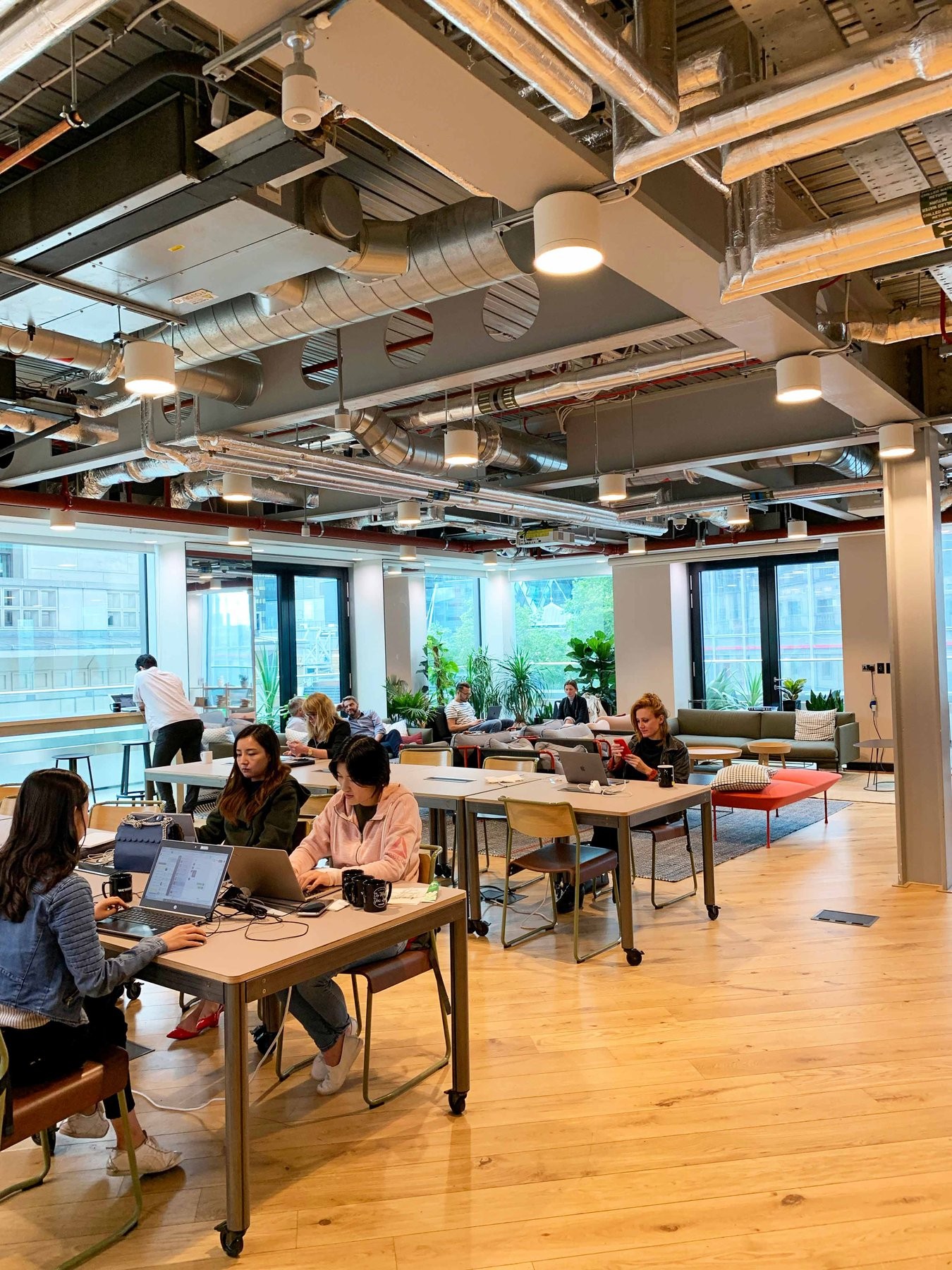 Employees in an open workspace layout with exposed ceilings
