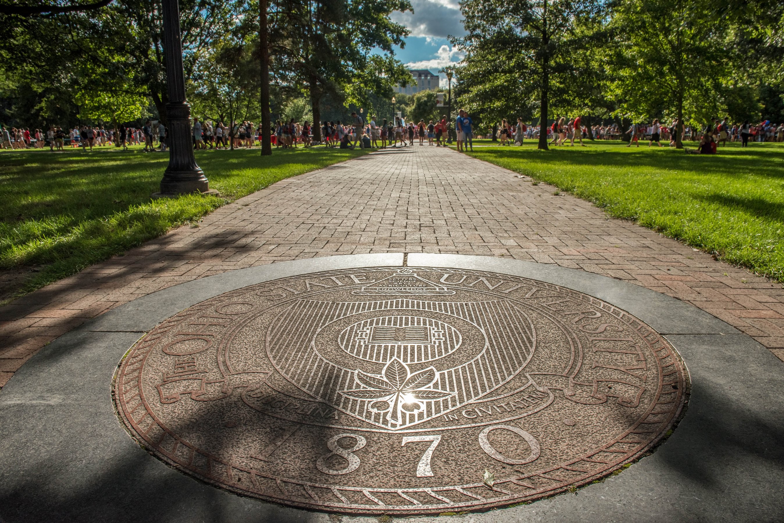 Students behind the seal on the campus of The Ohio State University