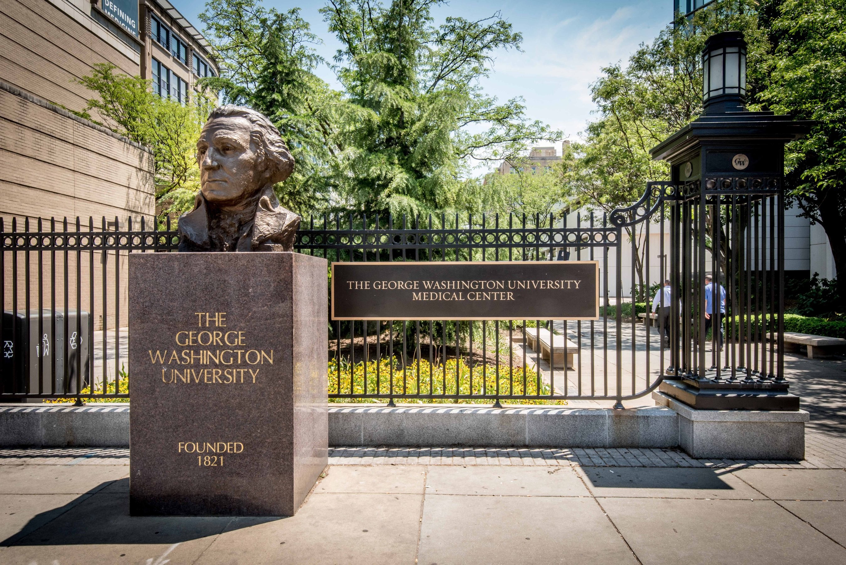 A bust of George Washington along a black metal fence at the entrance to the GWU Medical Center