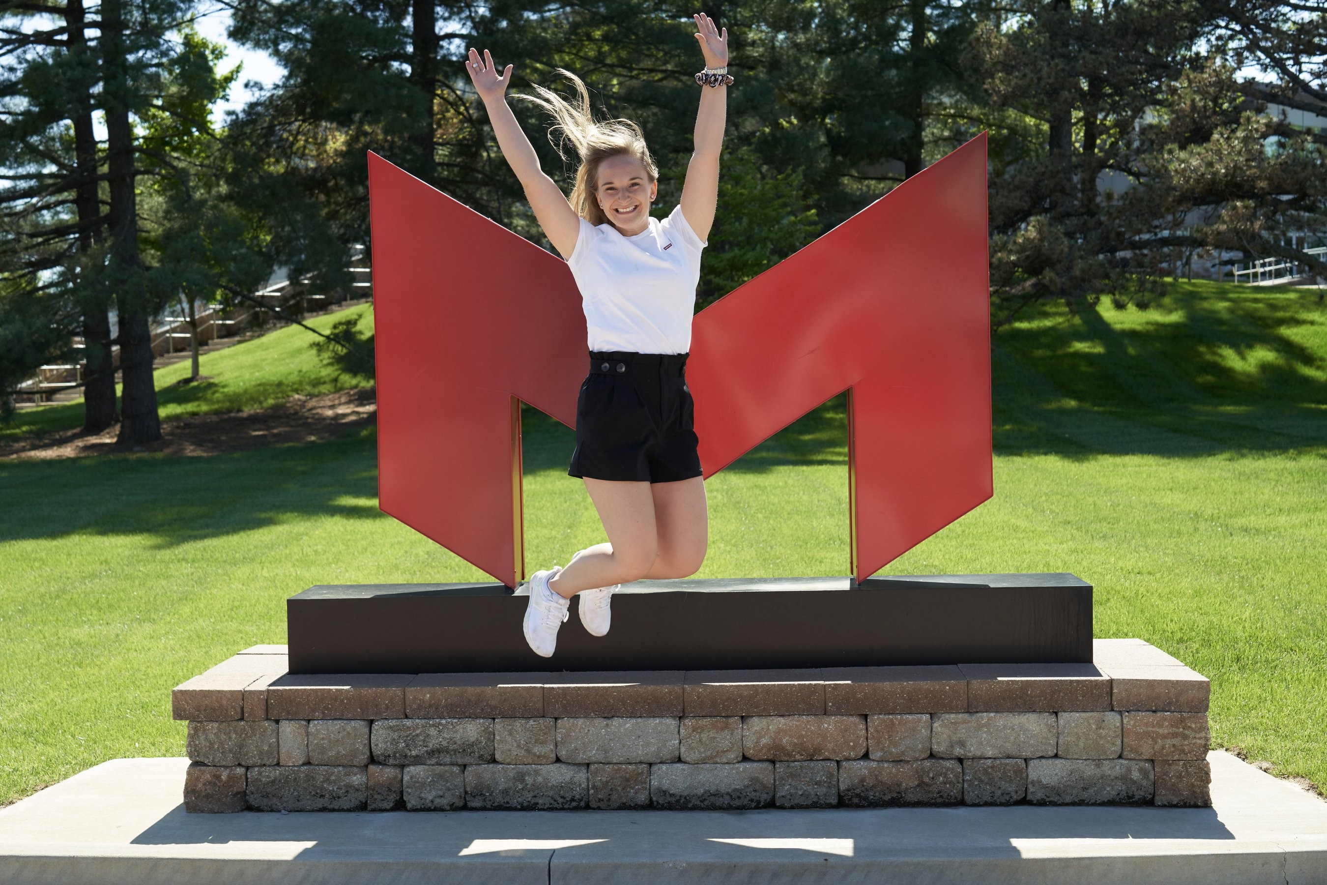 Image of student jumping in front of large 'M' Maryville University logo