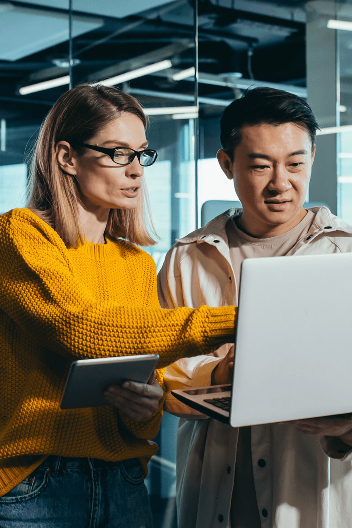 Woman in yellow and man looking at computer together