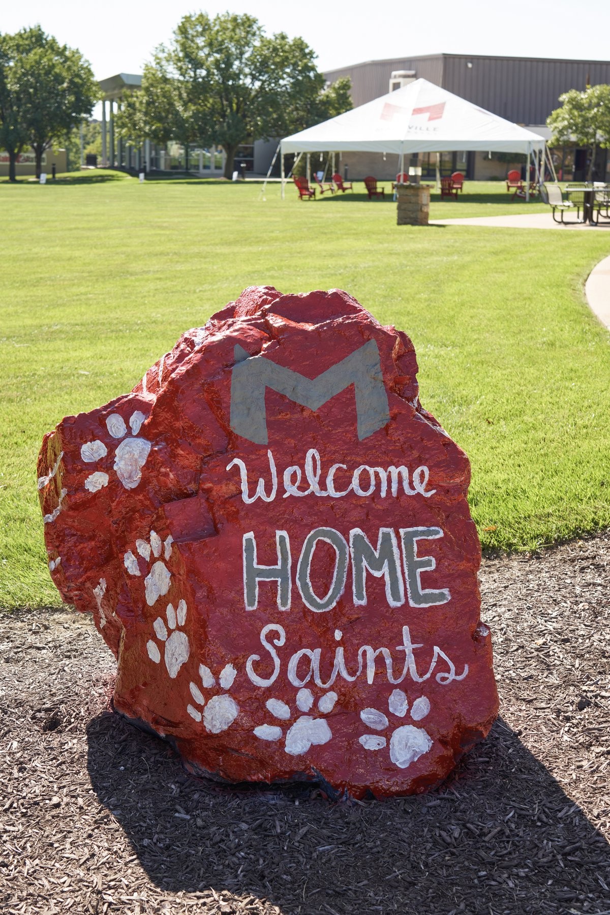 Image of painted rock with 'M' logo that says "Welcome Home Saints" on Maryville University's campus